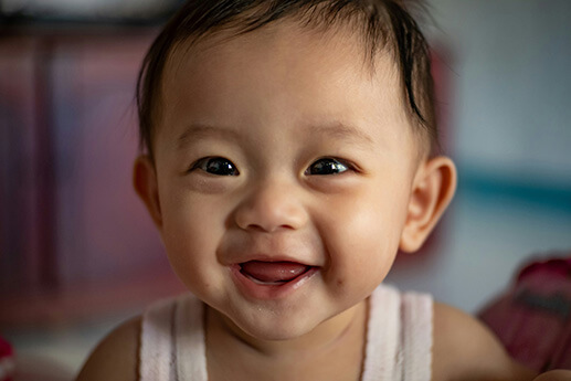 A baby boy smiling while at daycare. 