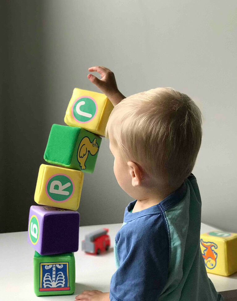 A young boy playing with colorful blocks.  
