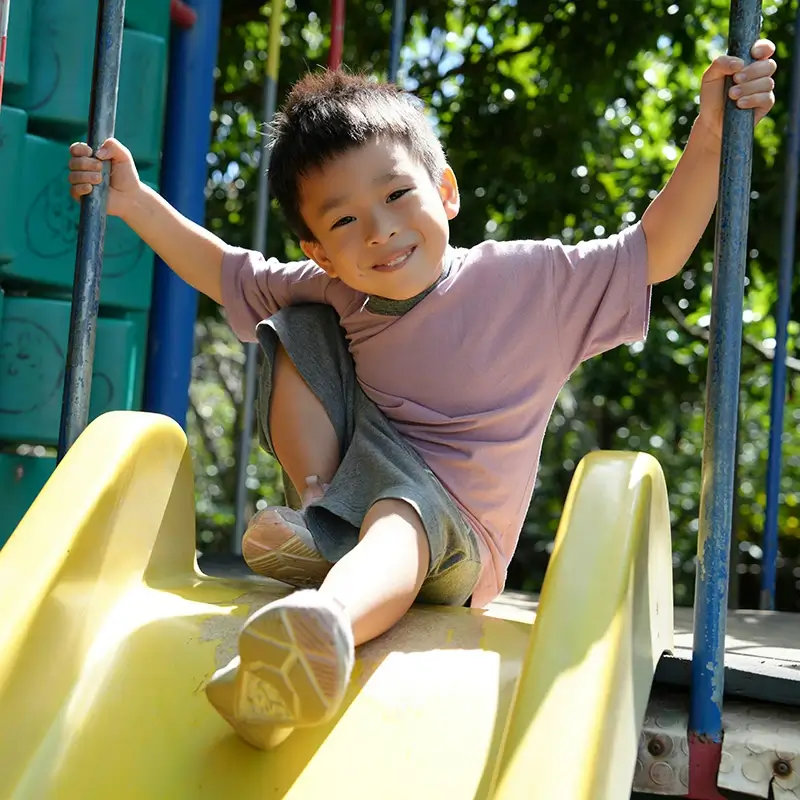 Smiling boy sitting on slide