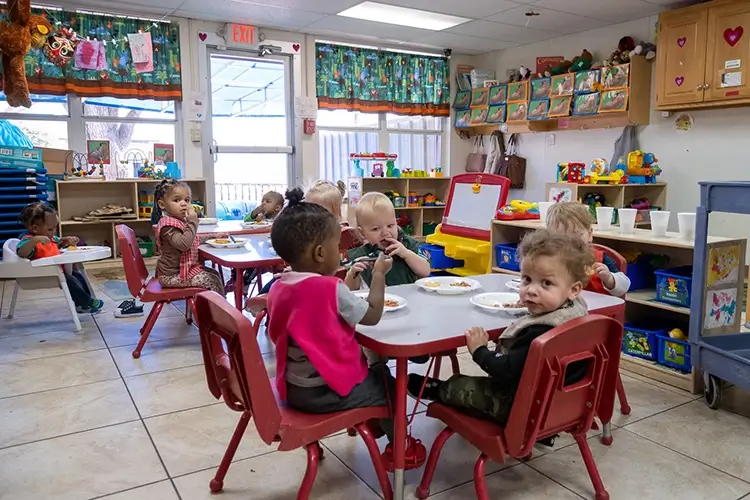 Children eating snack during weekend childcare near me
