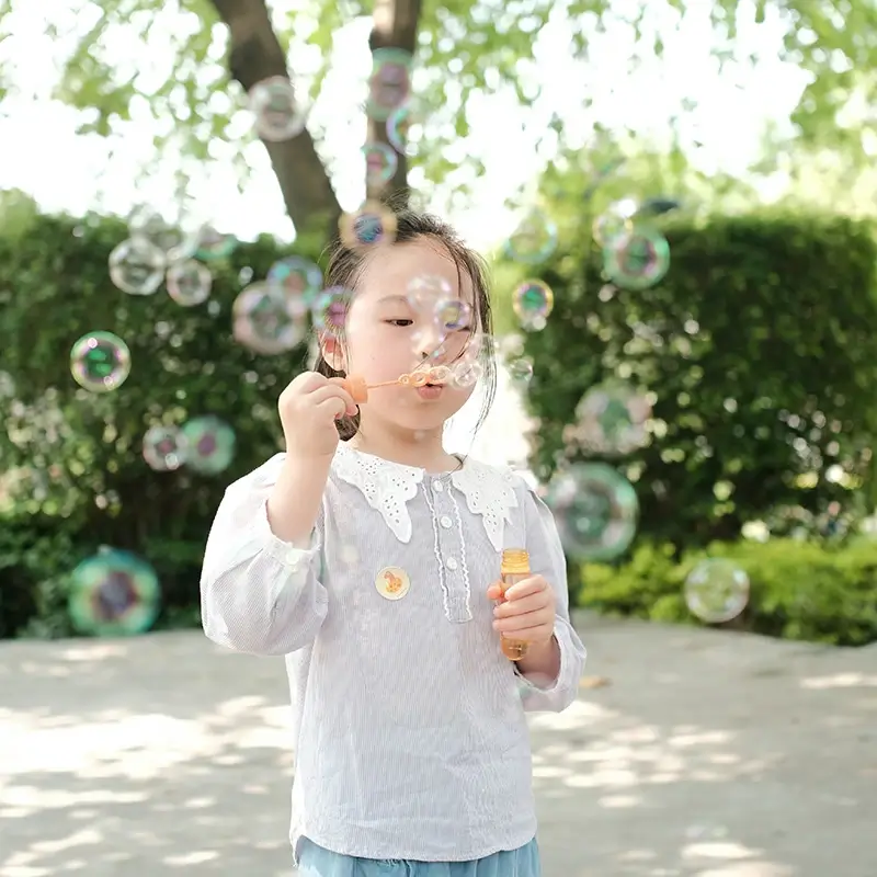 A little girl blowing bubbles outside at a summer camp Oklahoma City
