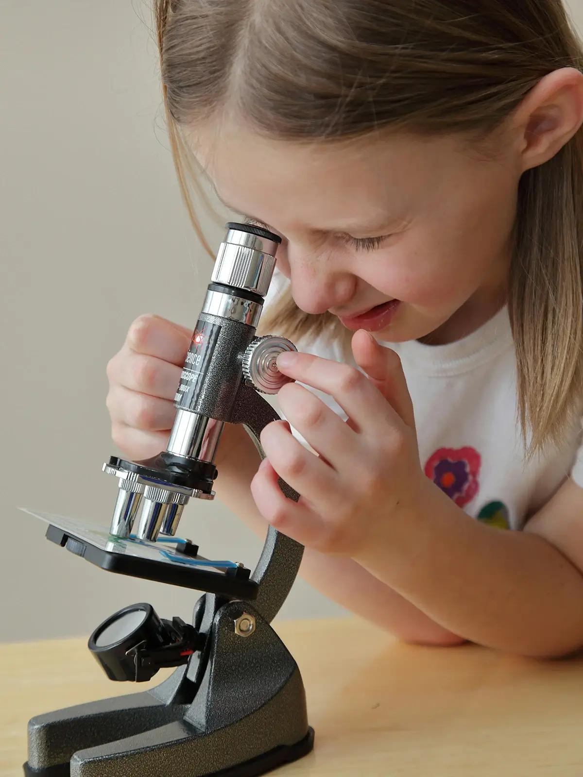 A young girl looking through a microscope